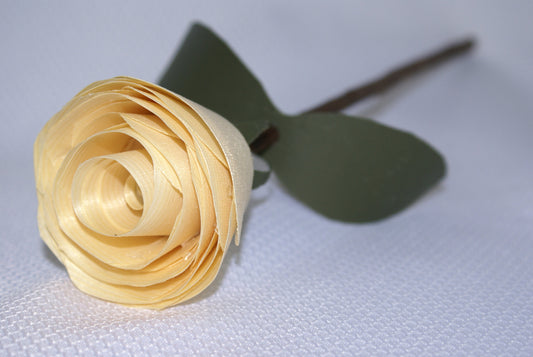 Handmade wooden rose on tree branch stem